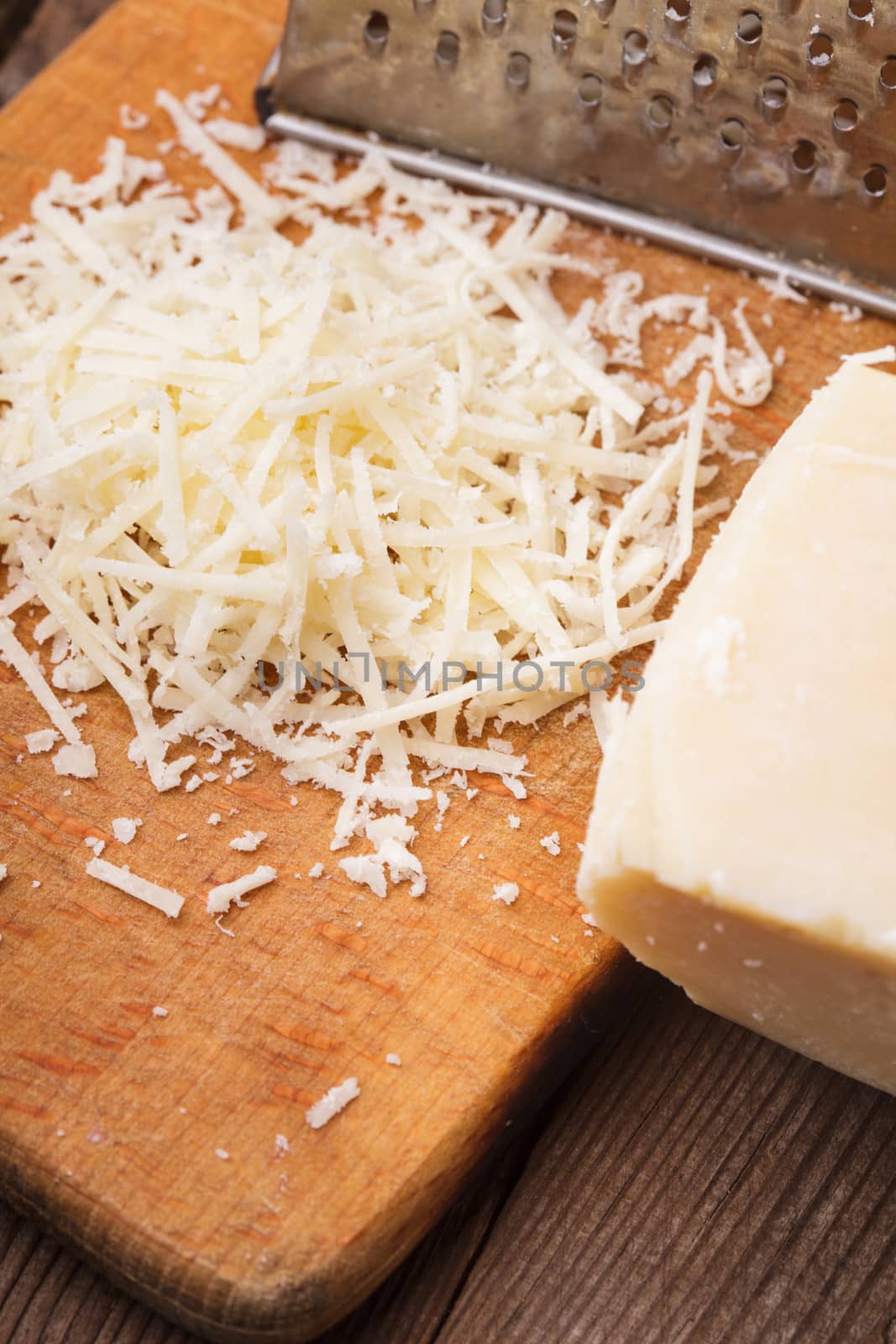 Grated Parmesan cheese with grater on a table