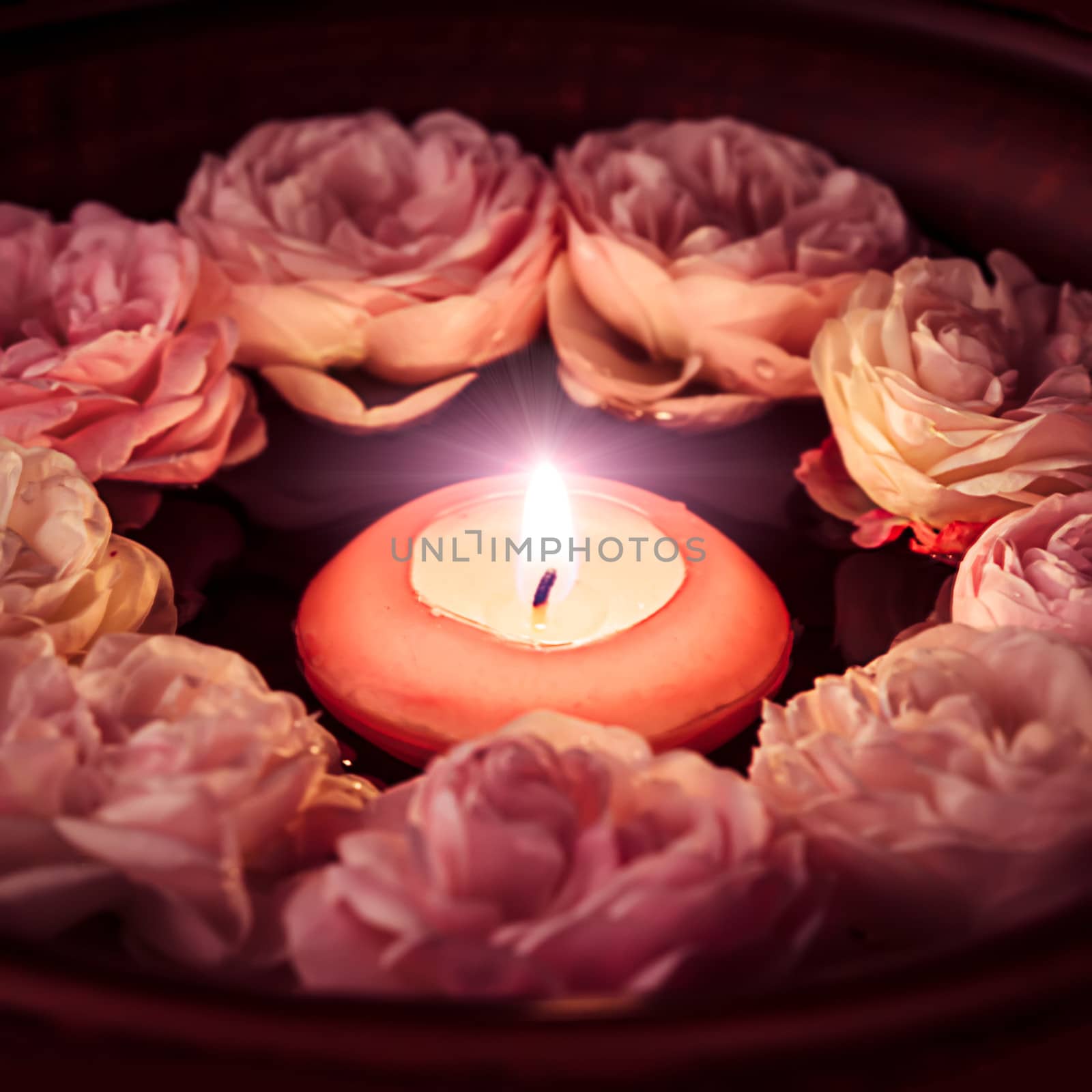 Spa relaxation - burned candle floating in rose water