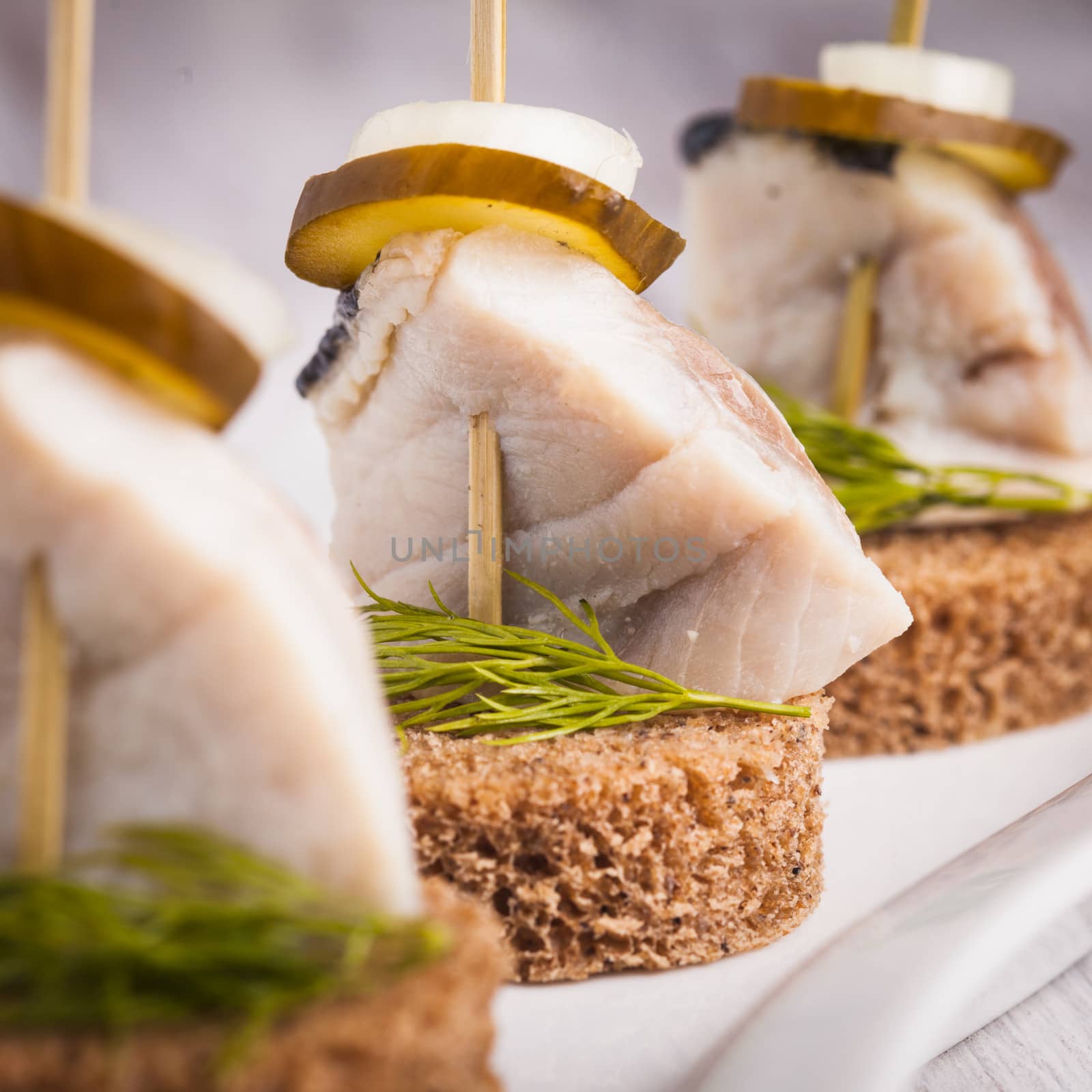 Herring canape with onion, pickled cucumber and dill