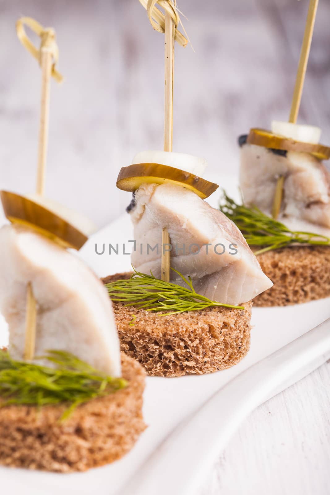 Herring canape with onion, pickled cucumber and dill