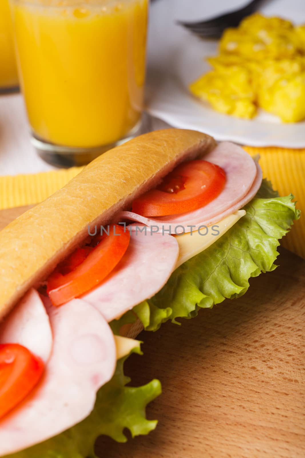 Breakfast with a sandwich, orange juice and scrambled eggs