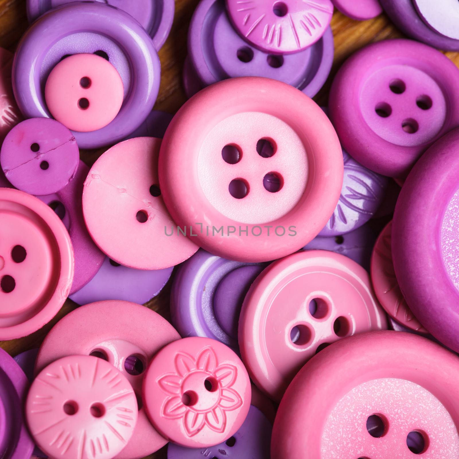 A lot of pink and purple sewing buttons closeup