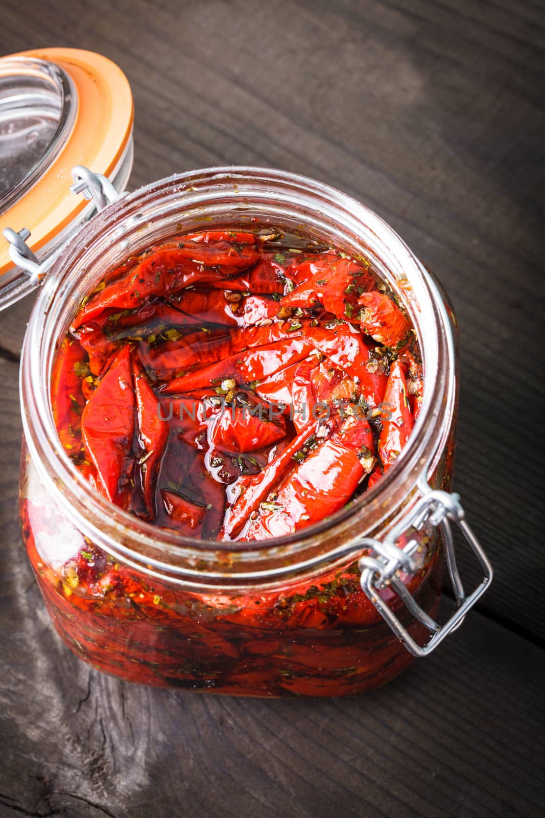 Sun dried tomatoes with herbs and olive oil in jar