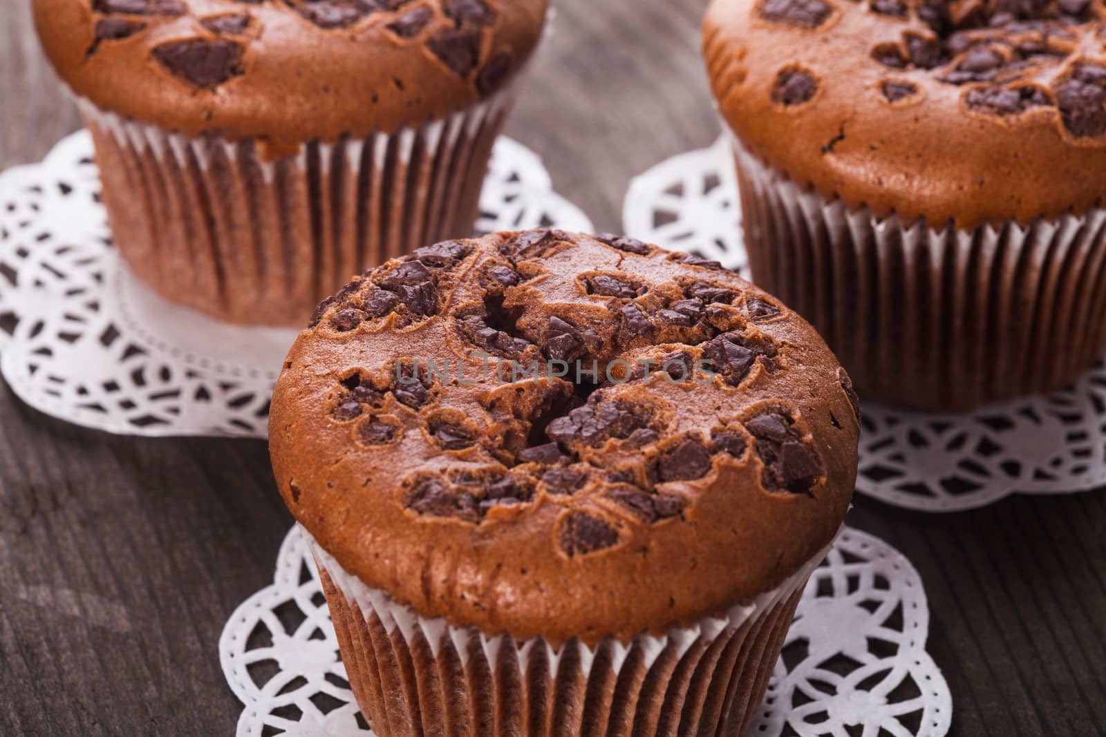 Chocolate muffins with chocolate chips on the wood background closeup