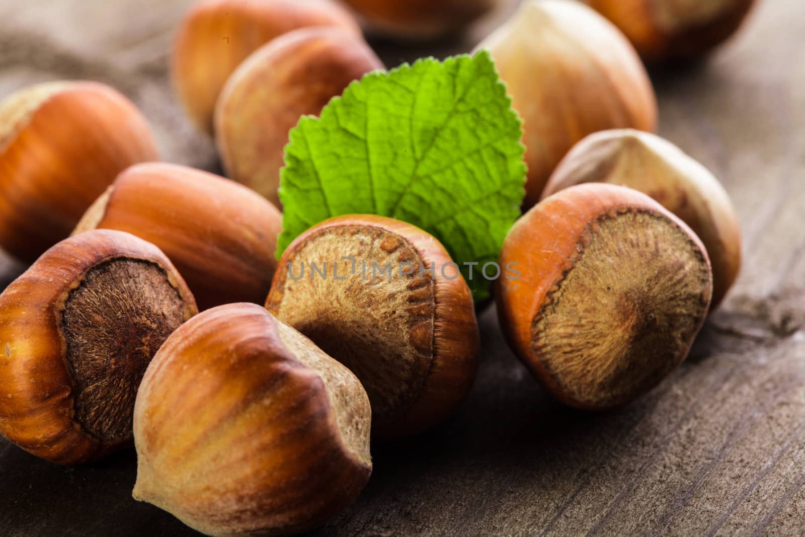 Hazelnuts with shell and green leaf on the wooden table