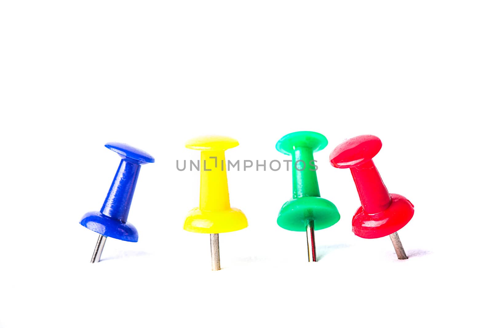 Multi-colored pushpins attached in white background isolated