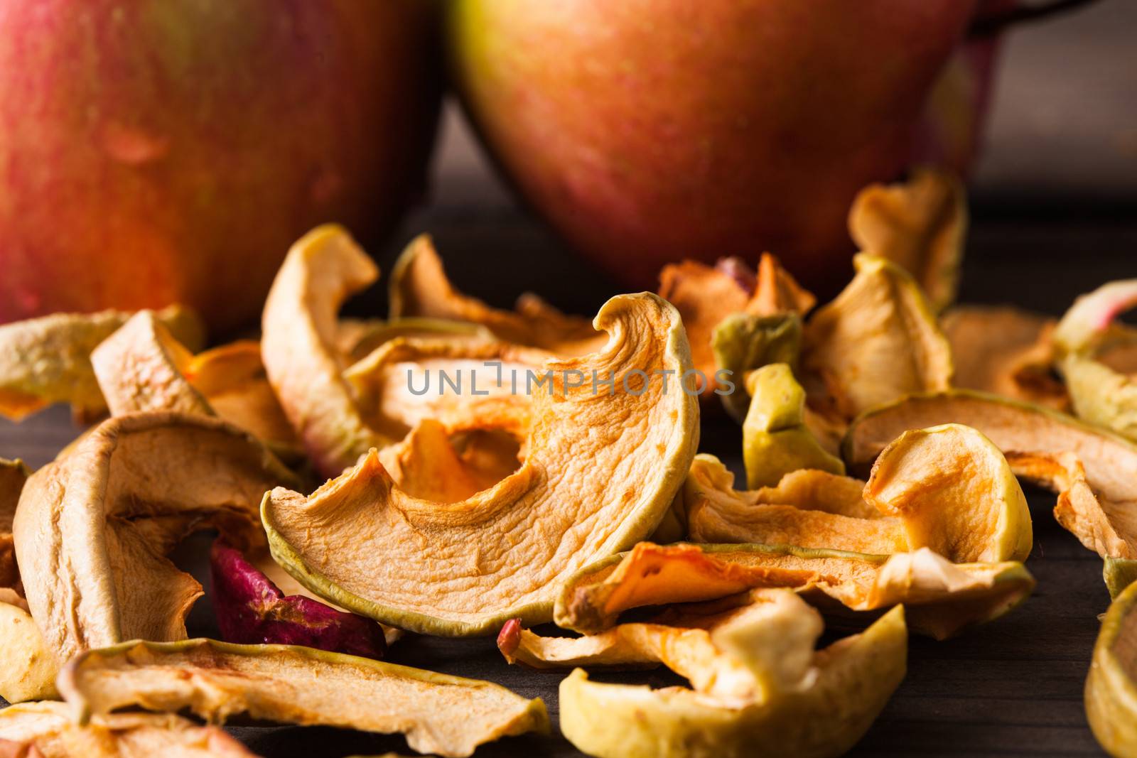 Slices of dried apples on fruit background closeup