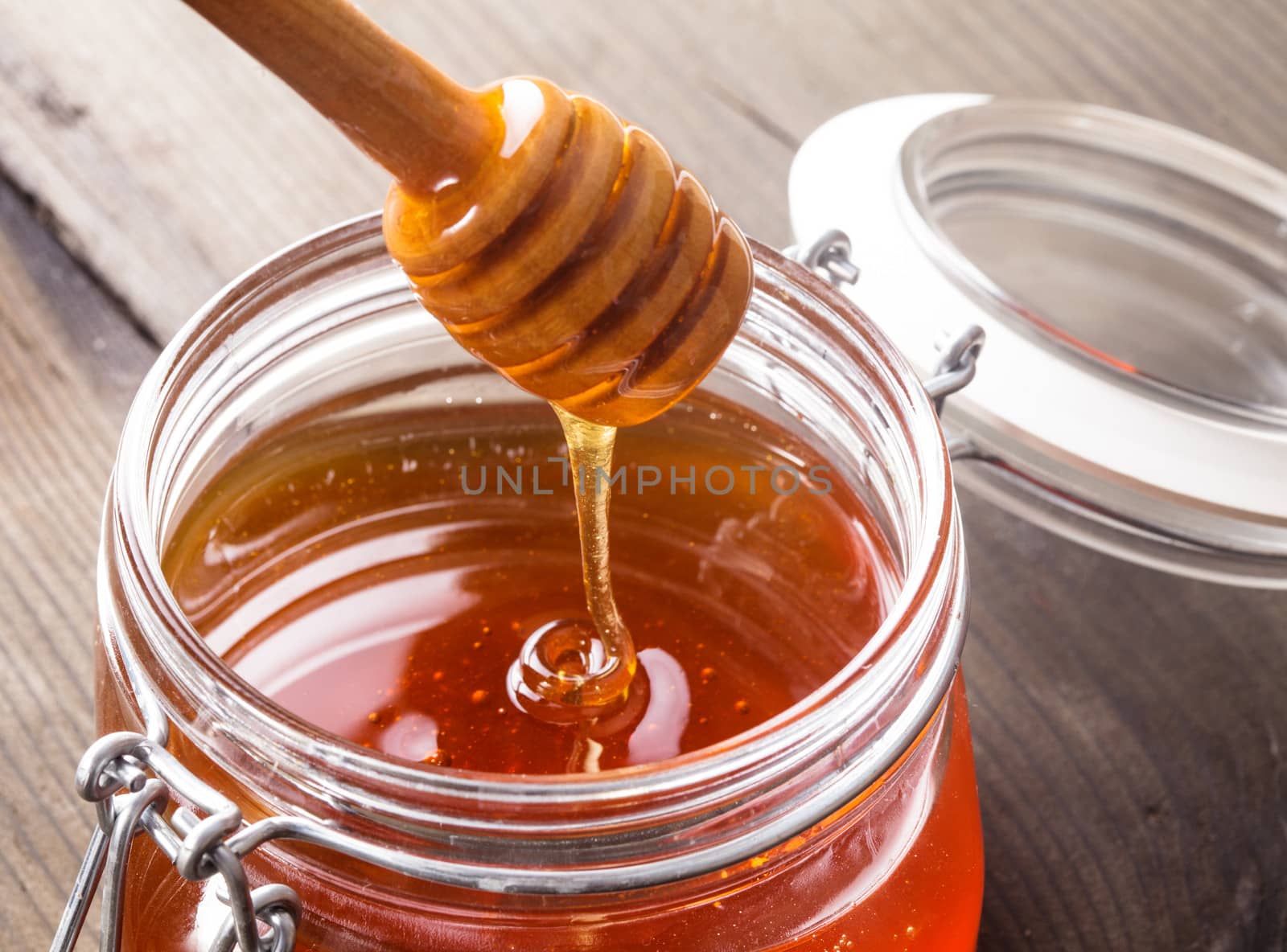 Honey drip in jar on the table