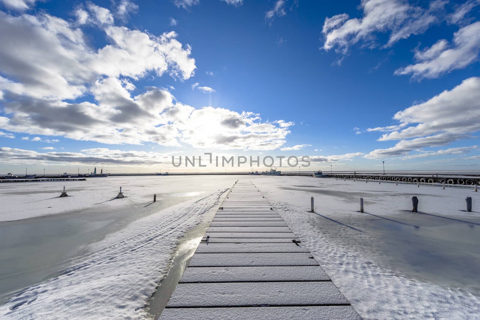A winter seaview on the pier, by entrance to the port, with froz by westernstudio