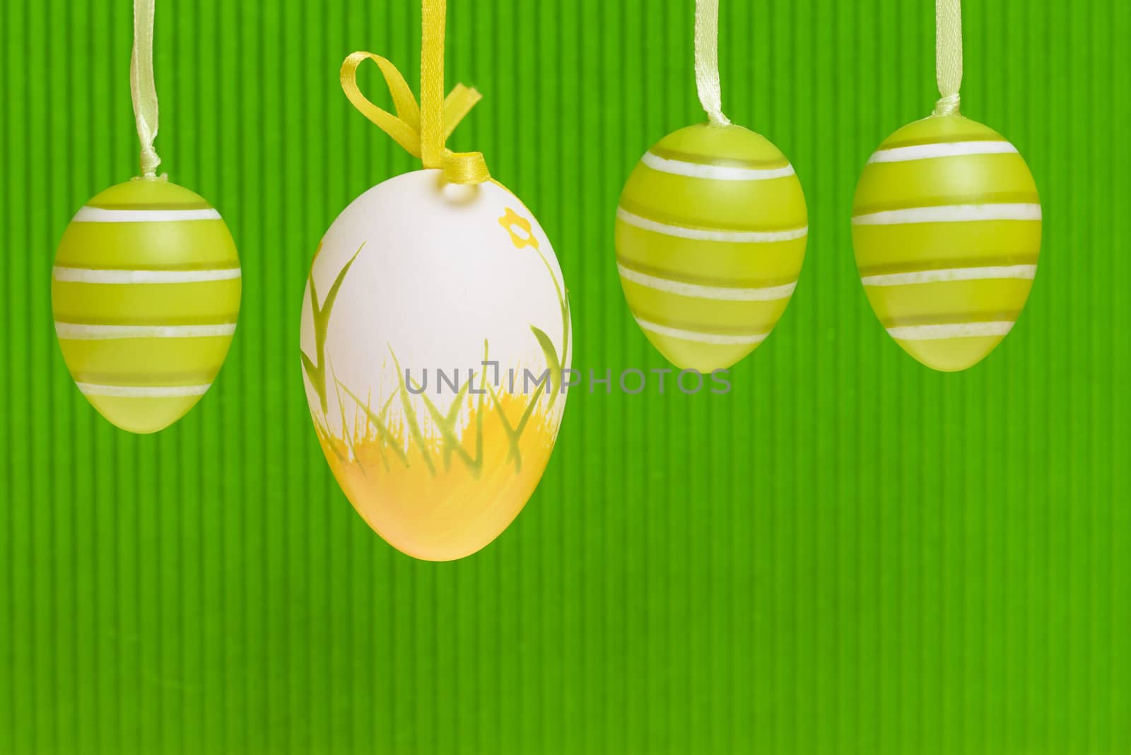 Easter decorated eggs on green backround, eggs in white and green and yellow colours.