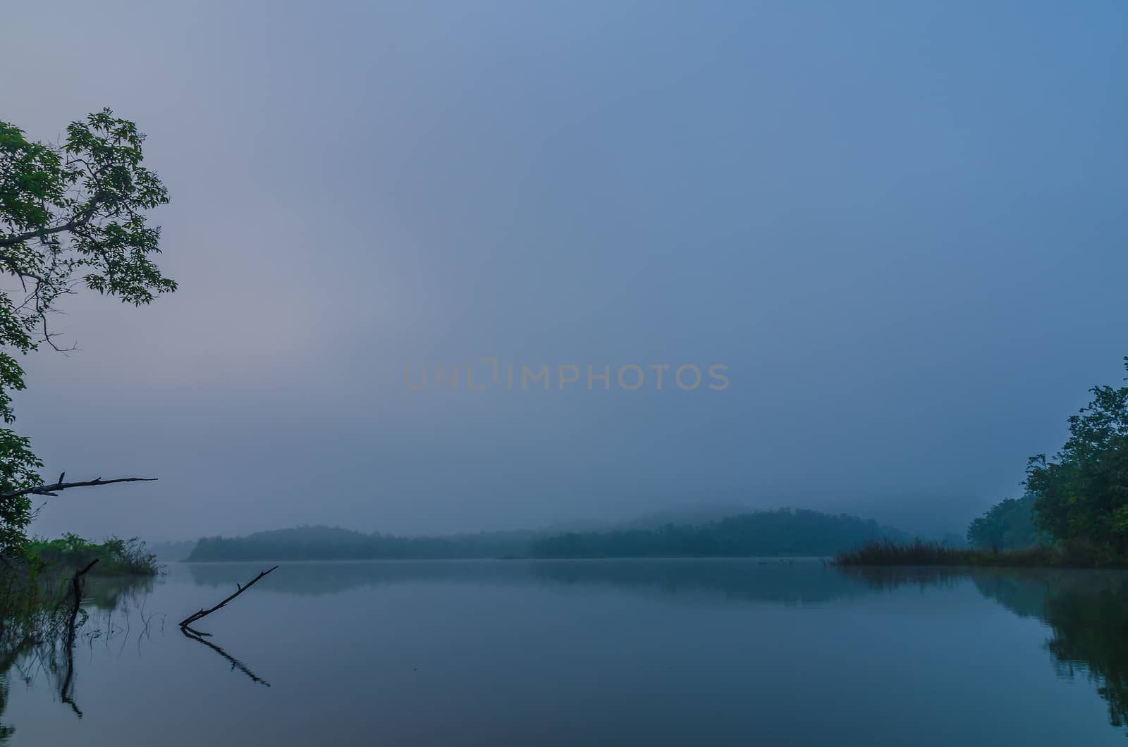 The lake in the morning with tranquil water and slight fog