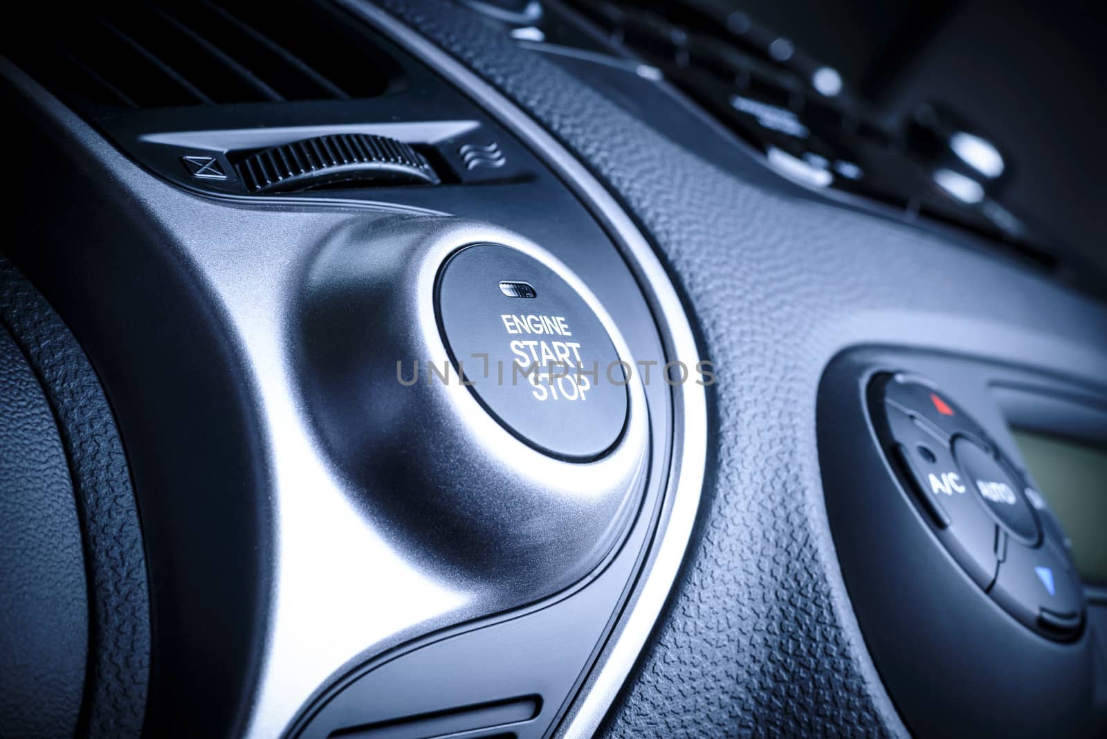 START/STOP ignition button in car, vehicle with visible fragment of instrument panel in vehicle interior.