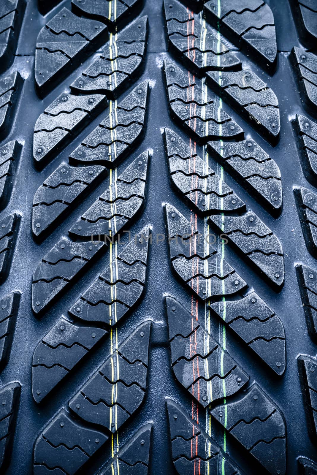 Fragment of new vehicle or car tyre, tire with visible tread and colour mark.