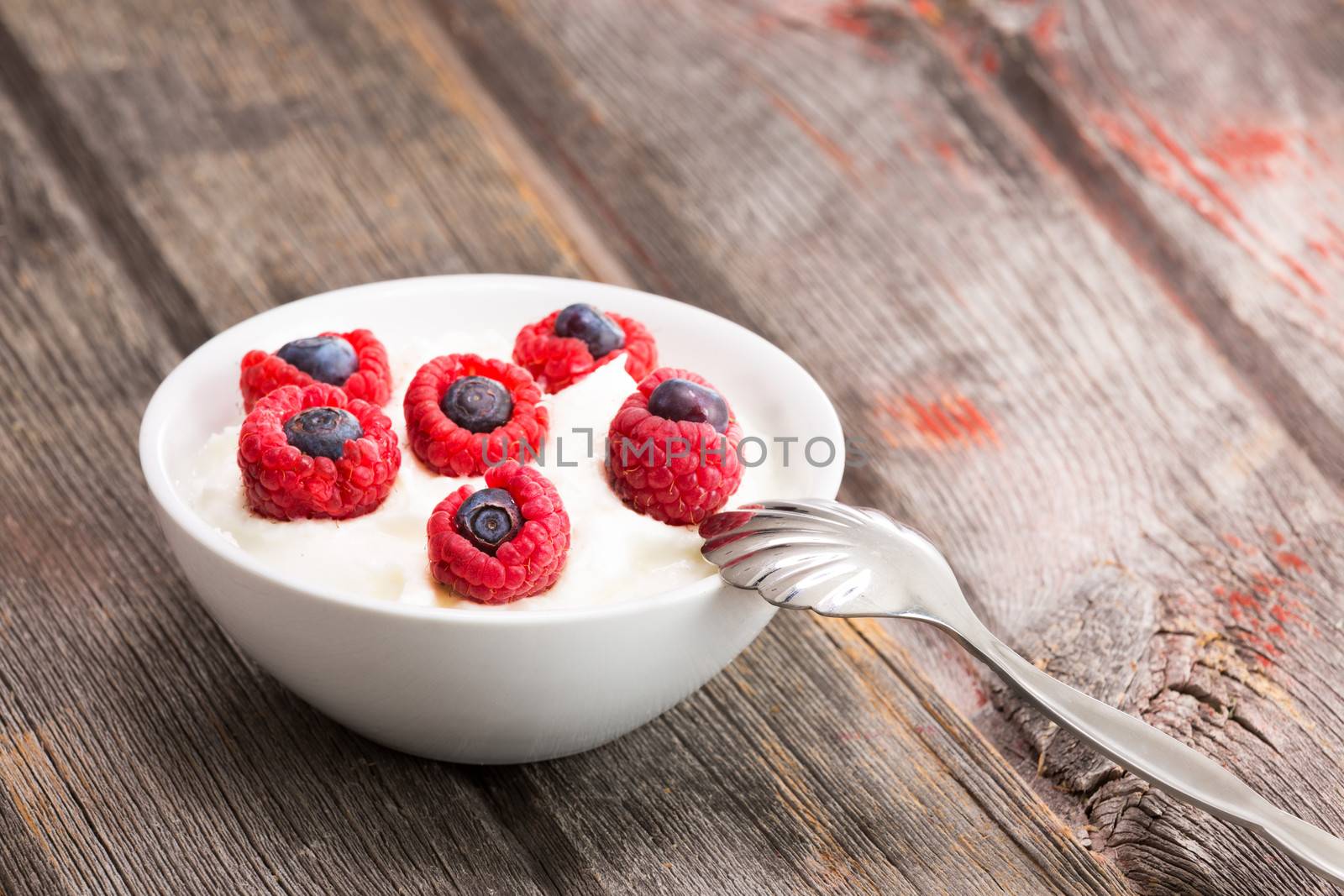 Fresh raspberries and blueberries with yogurt by coskun