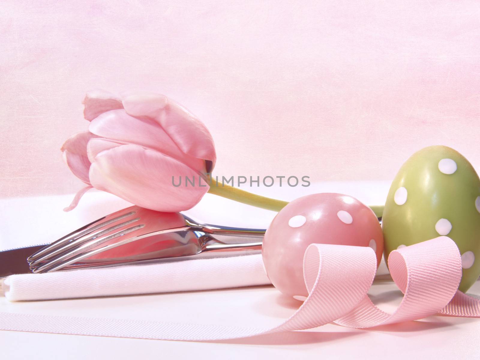 Closeup of utensils and pink tulip on pink  by Sandralise
