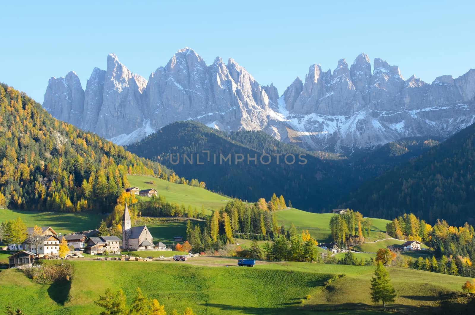 St. Magdalena with its characteristic church in front of the Geisler Dolomites mountain peaks in the Villnosstal in Italy in autumn.