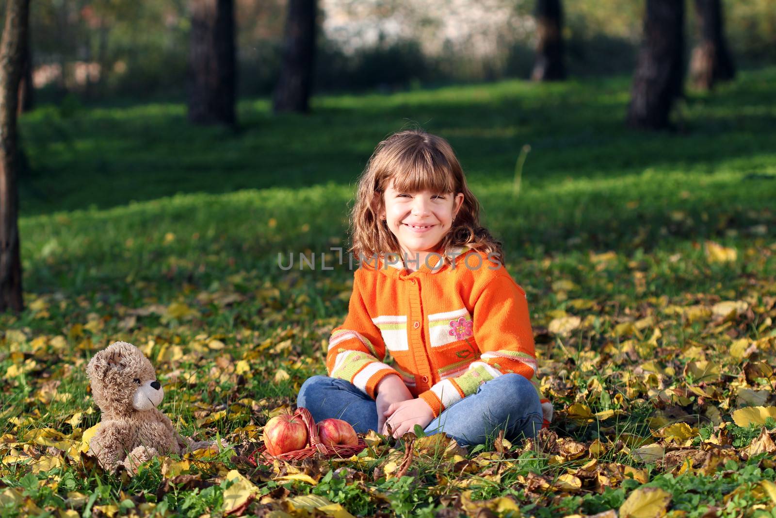 happy little girl sitting in park by goce