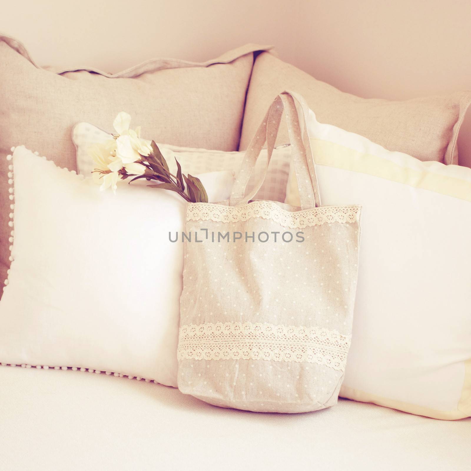 Cute tote bag and pillows on bed with retro filter effect
