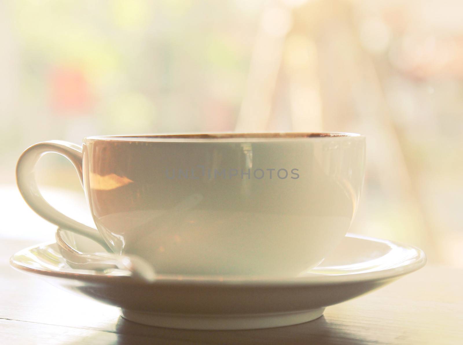 Closeup of coffee cup on table at coffee shop with retro filter  by nuchylee