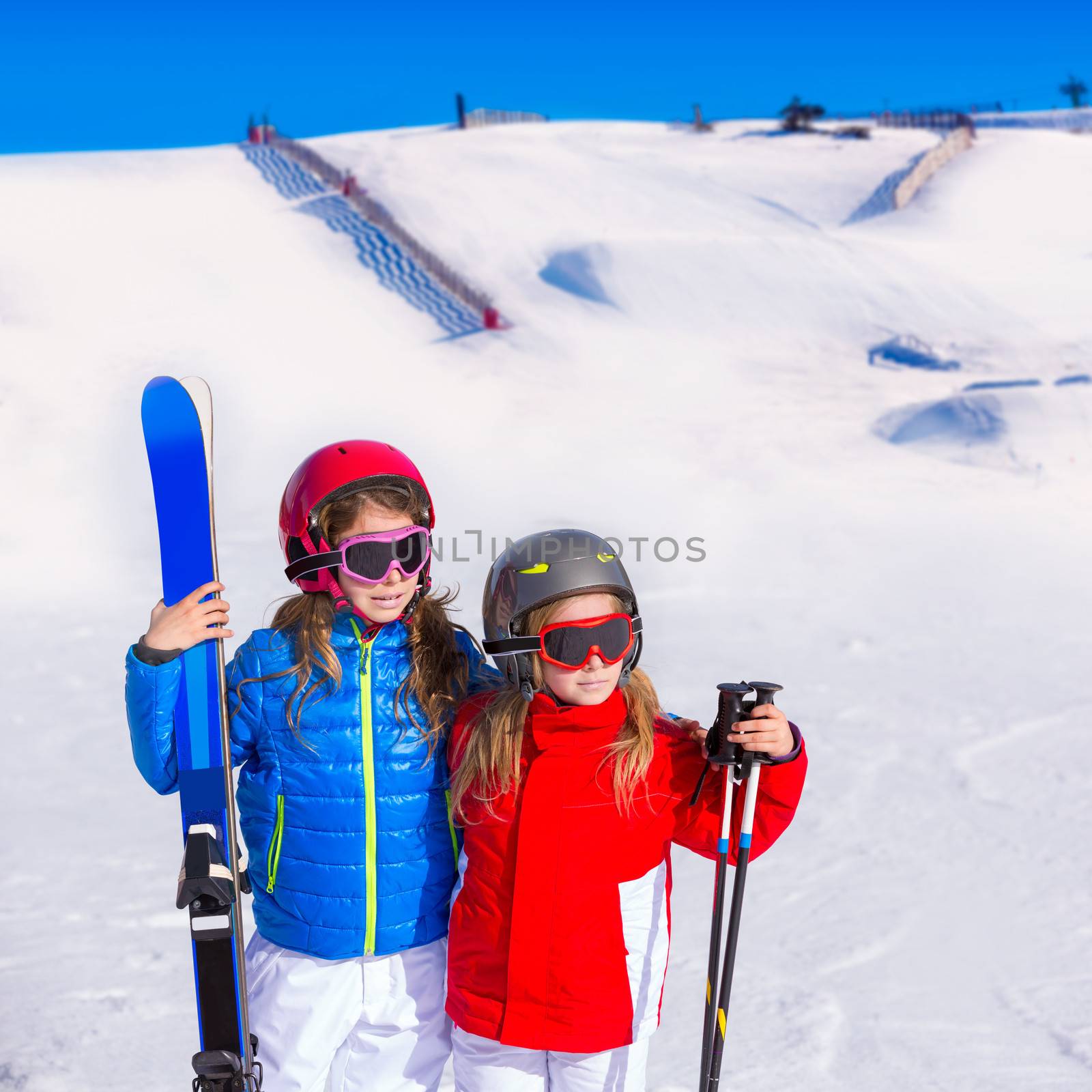 Kid girls sister in winter snow with ski equipment by lunamarina