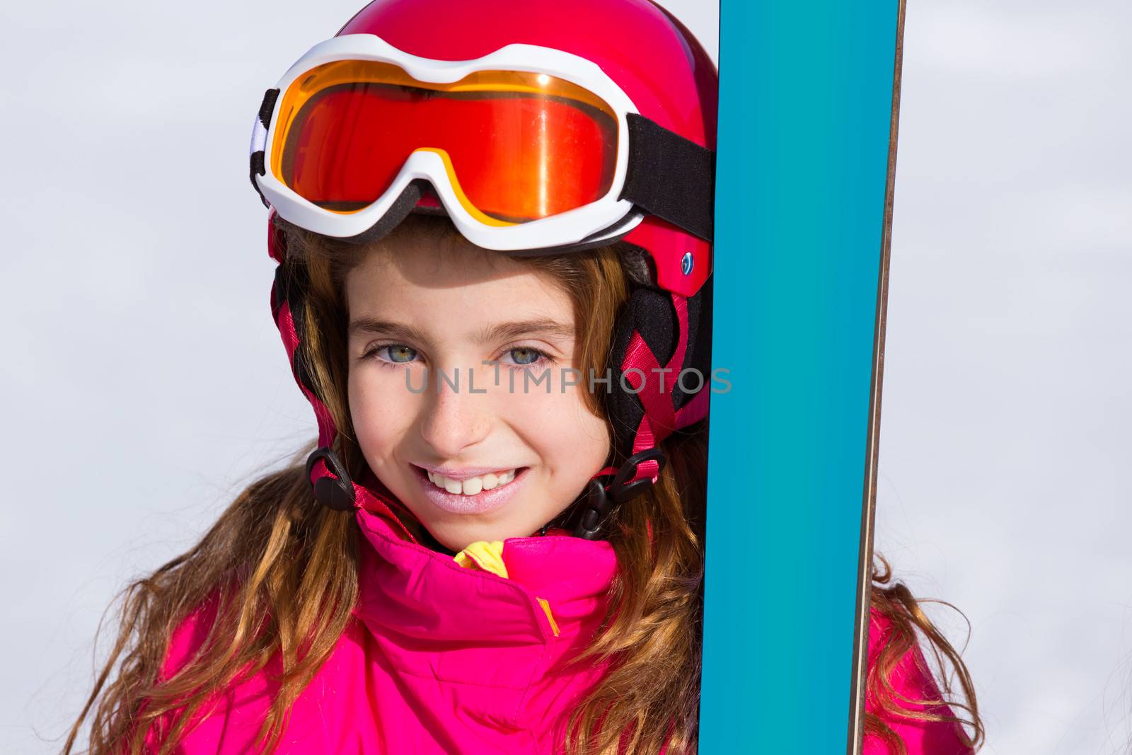 Kid girl winter snow portrait with ski equipment helmet and goggles