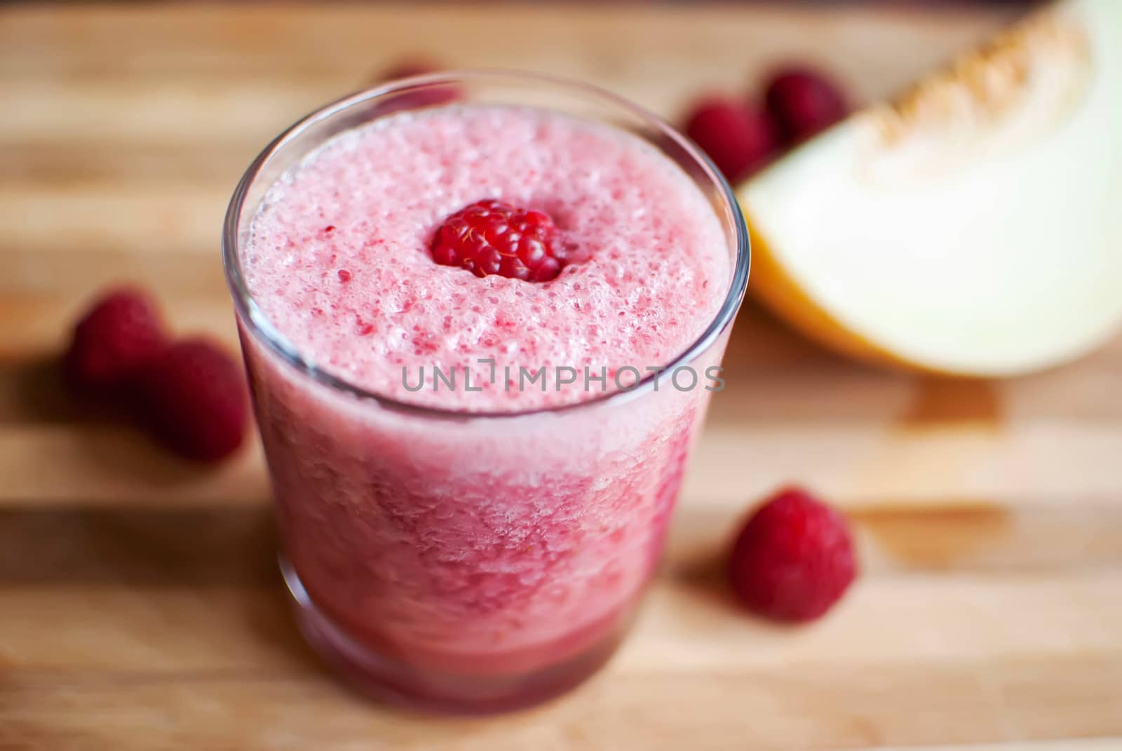 healthy raspberry and melon juice over wood