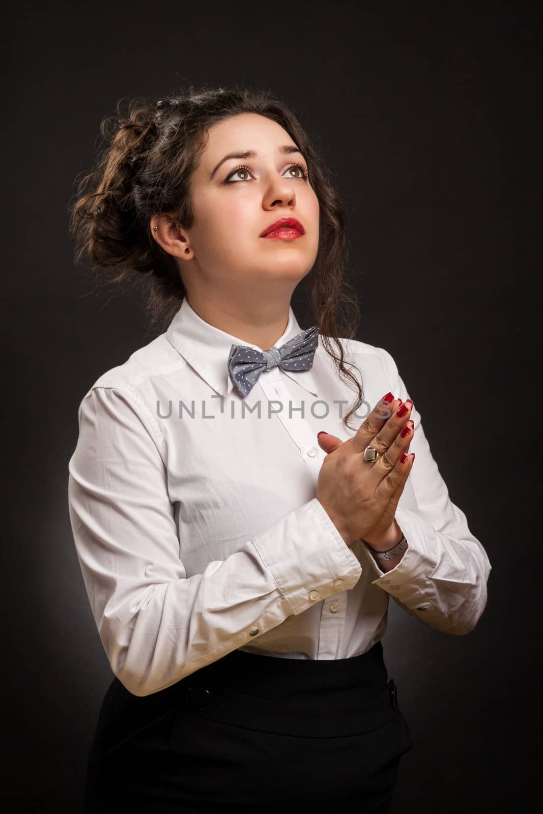 adult stylish woman praying, with dark background