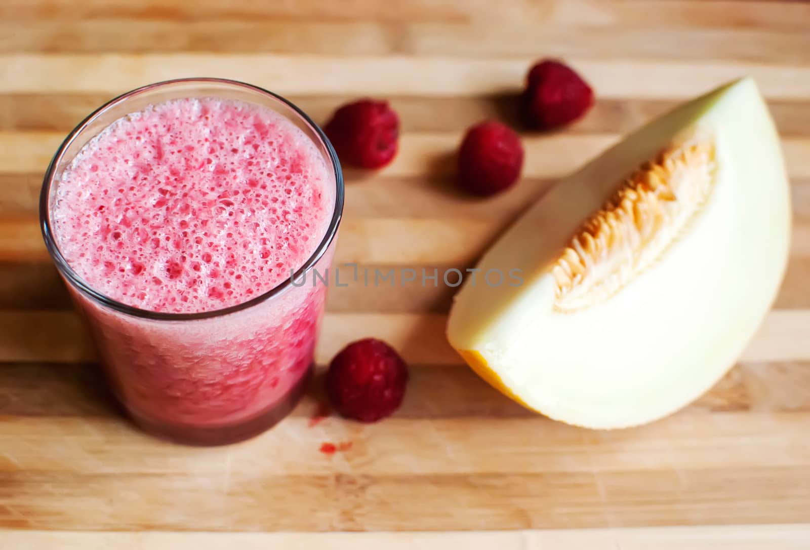 healthy raspberry and melon juice over wood