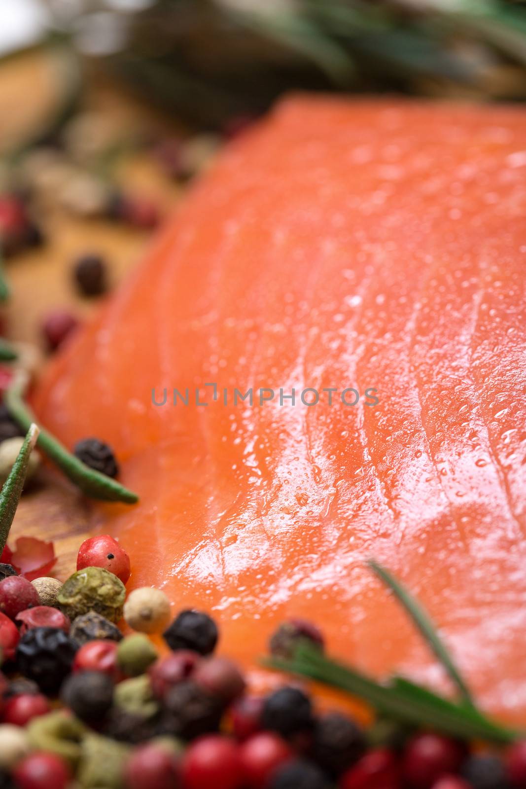Piece fresh salmon with spices, closeup on wooden background