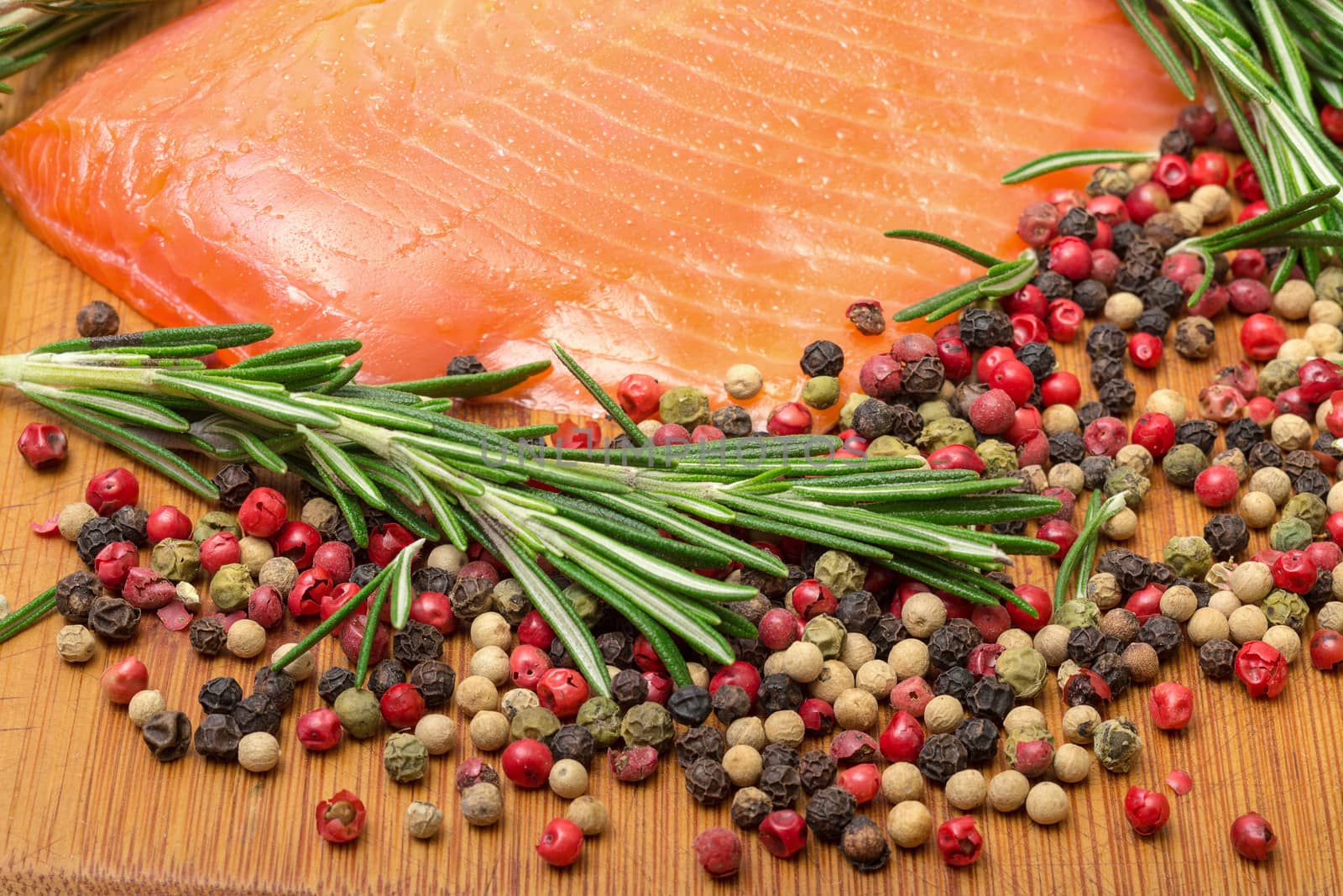 Piece fresh salmon with spices, closeup on wooden background