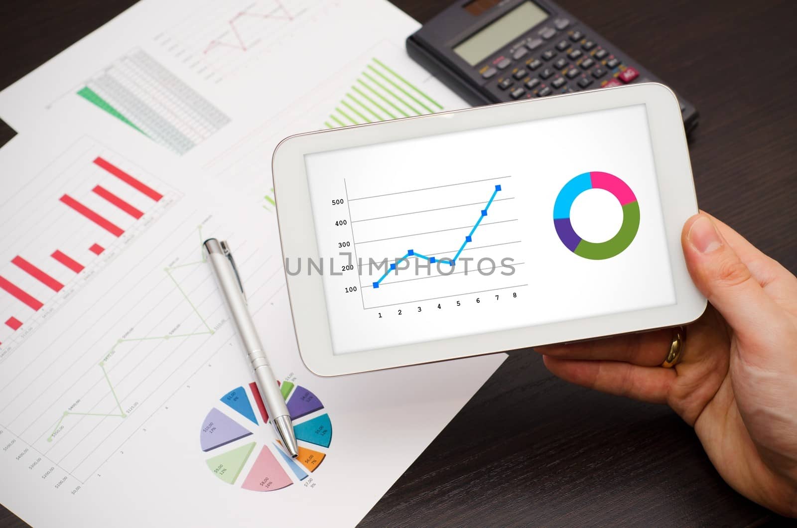 Businessman working with tablet pc. Report charts in background by simpson33