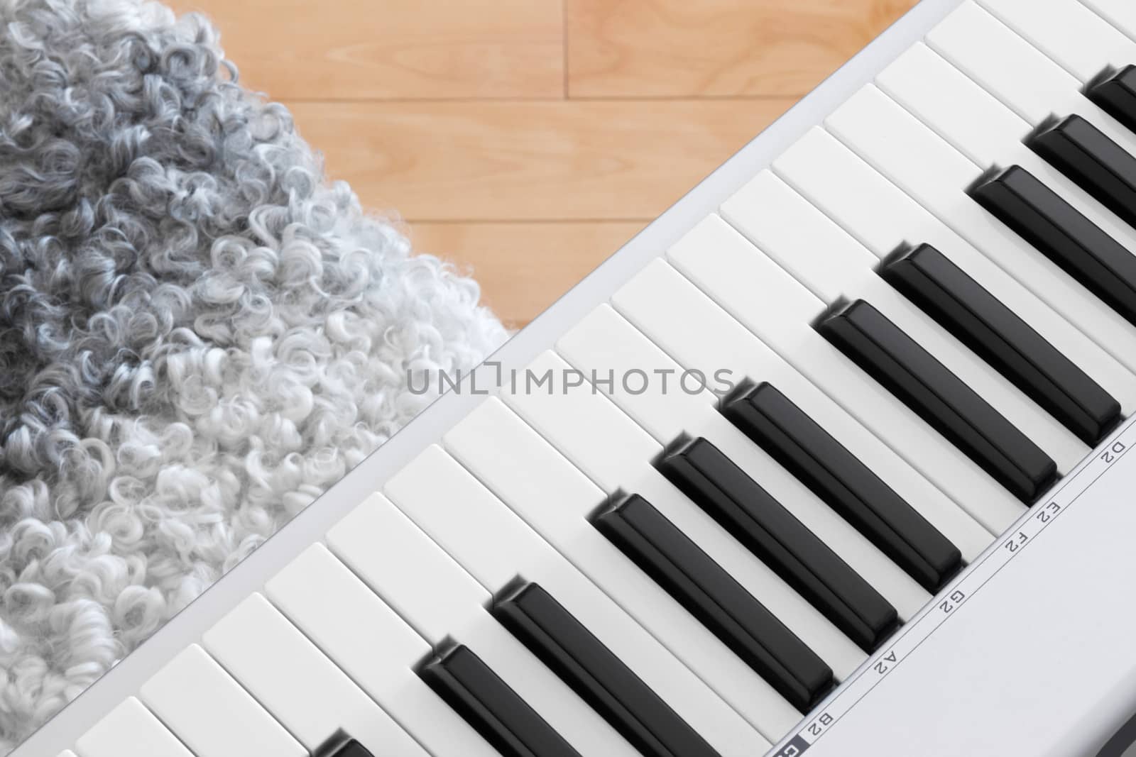 Close-up of electric piano keys and chair.