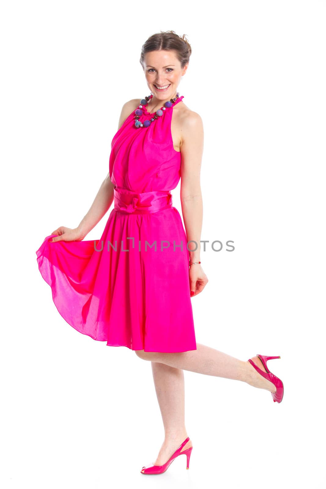 Full length of cute female fashion model posing in pink dress. Isolated on white, studio shot