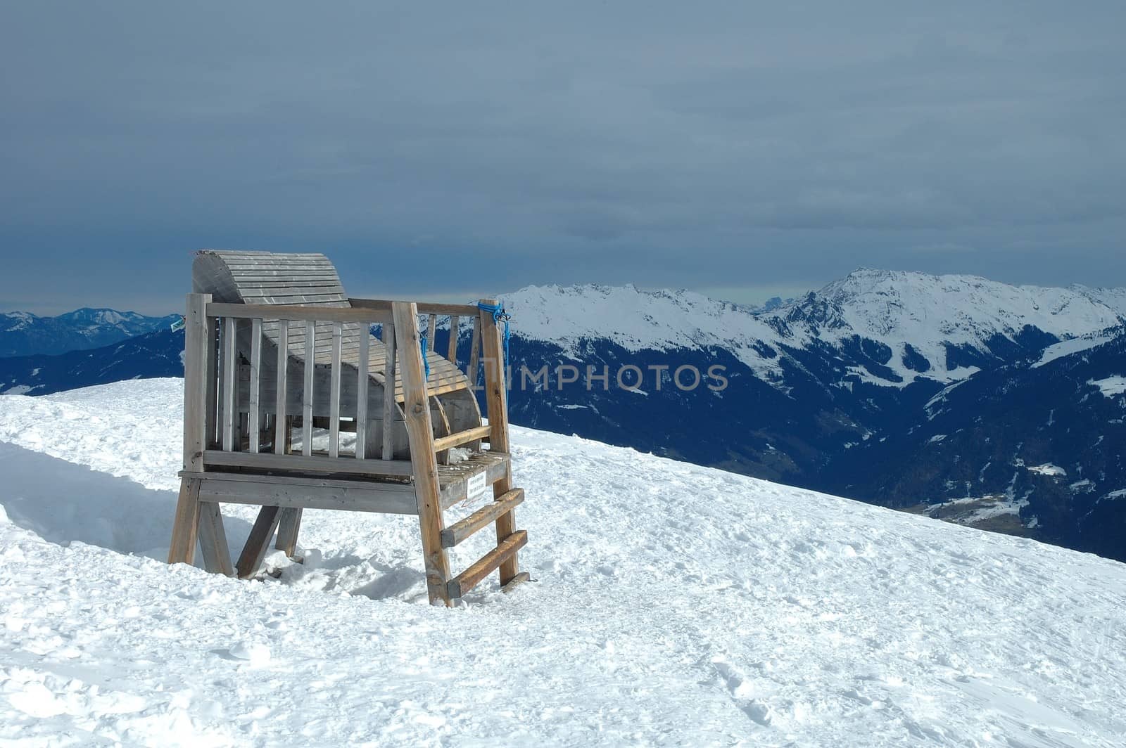 Big wooden chair in Alps in winter by janhetman