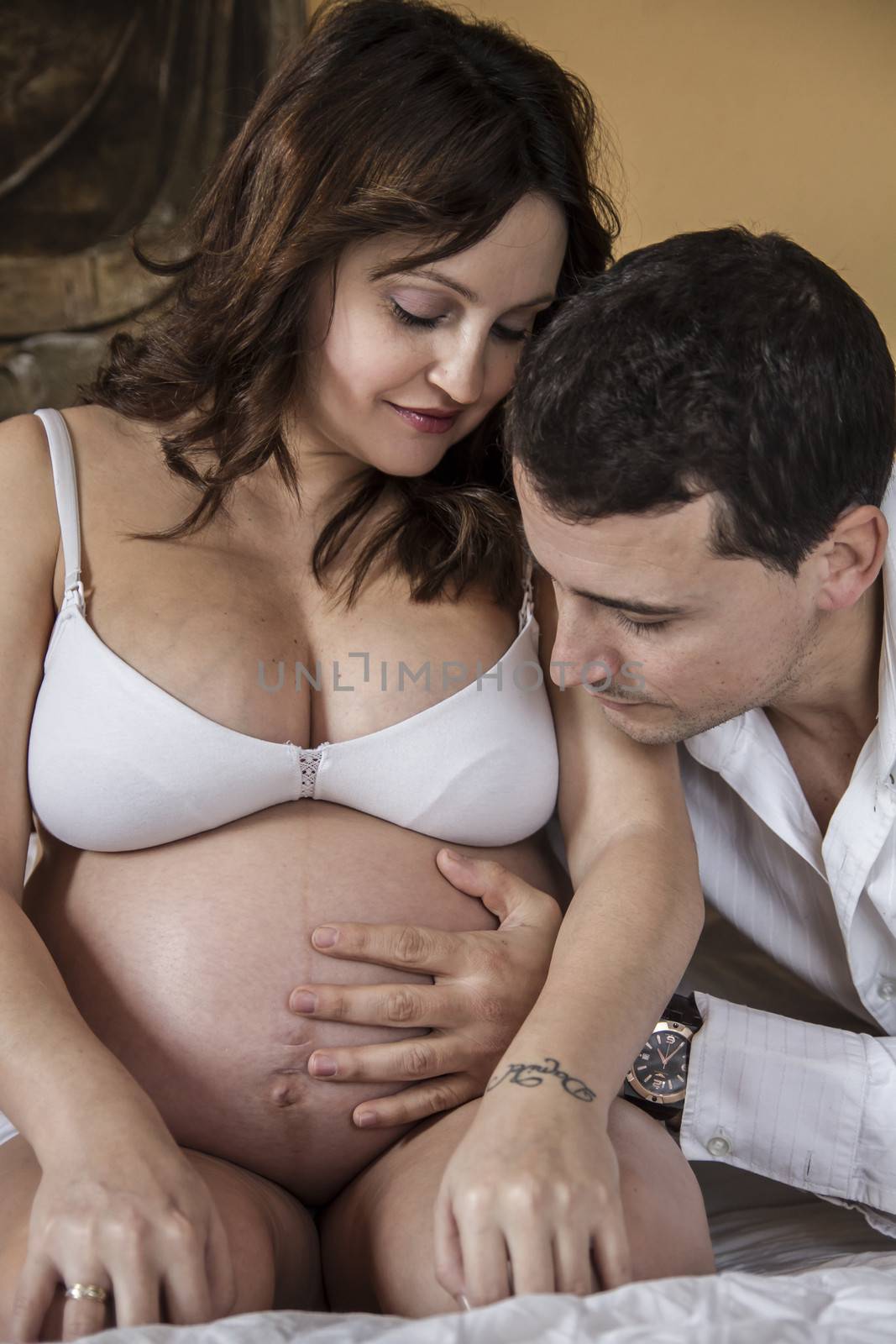 Father, Family With Pregnant Mother Relaxing On bed Together