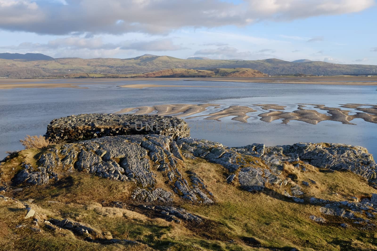 A flat topped view point looks out over an estuary and distant mountain range.