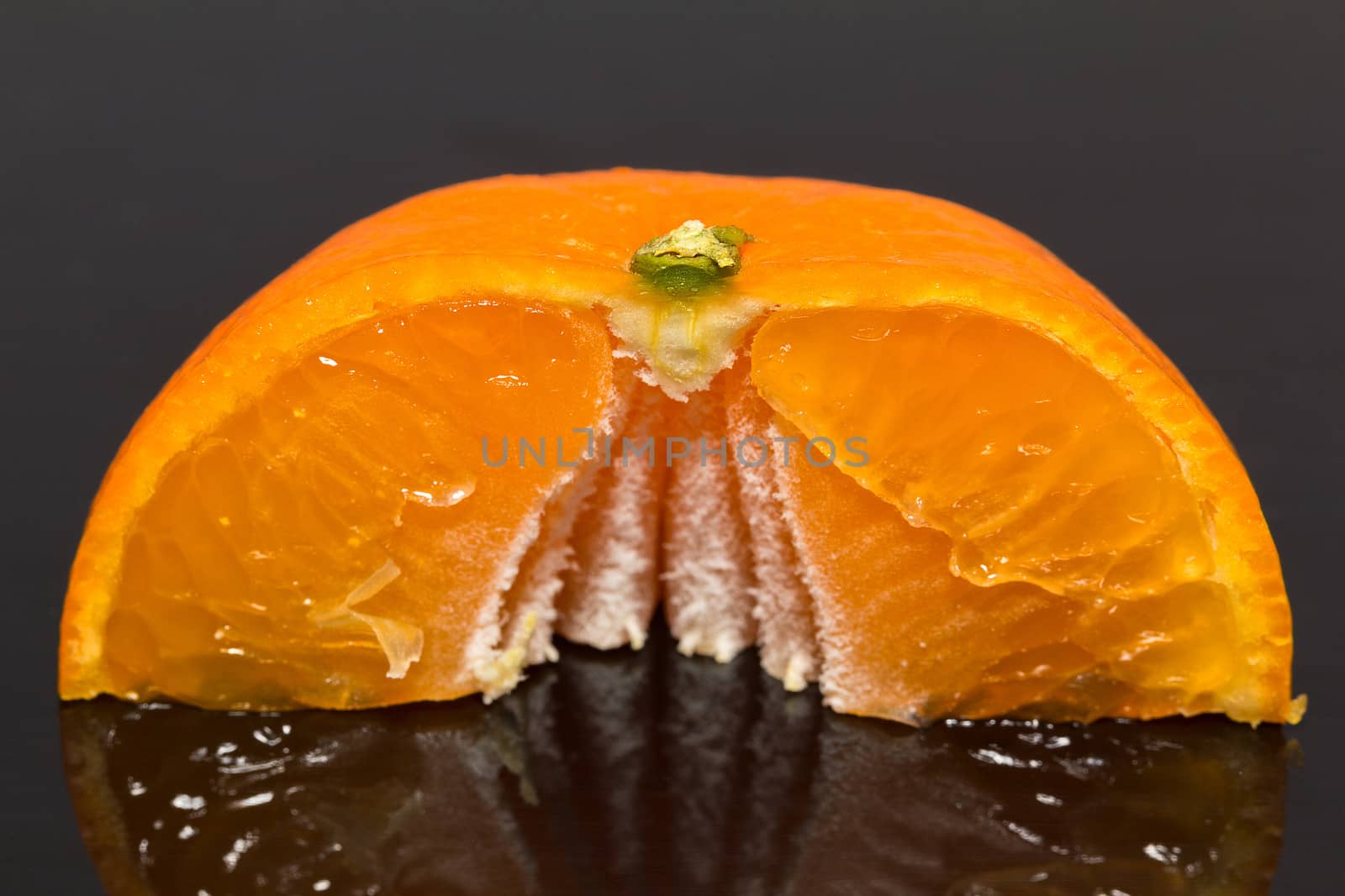 isolated half of mandarine on dark background