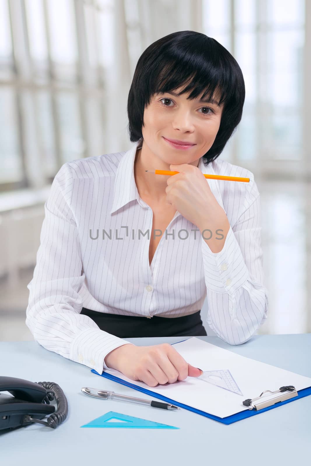 asian businesswoman sitting at table and looking at camera by mihalec