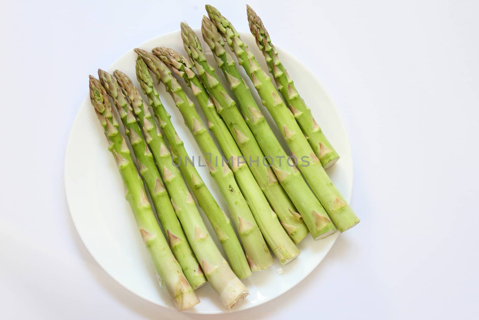 Green vegetable Asparagus bundle in a white plate