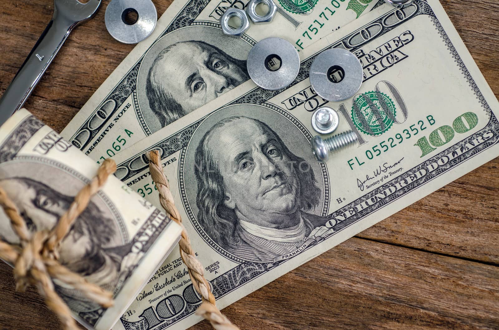 Close up bolts nuts and money on wood table