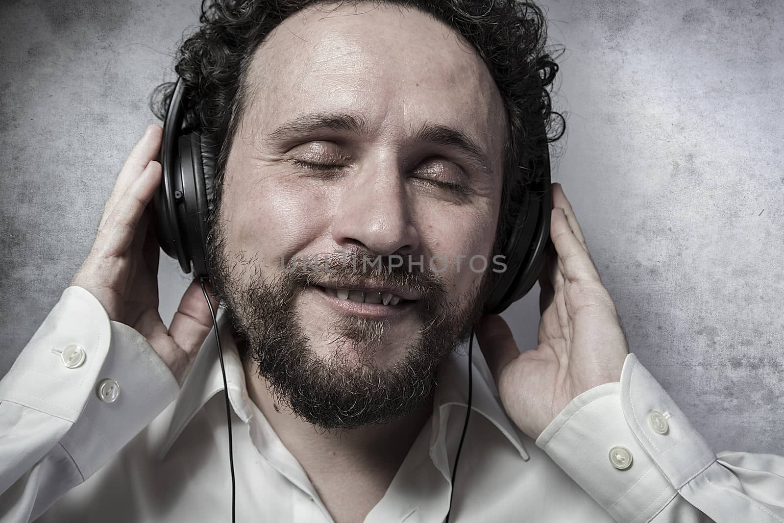 listening and enjoying music with headphones, man in white shirt by FernandoCortes