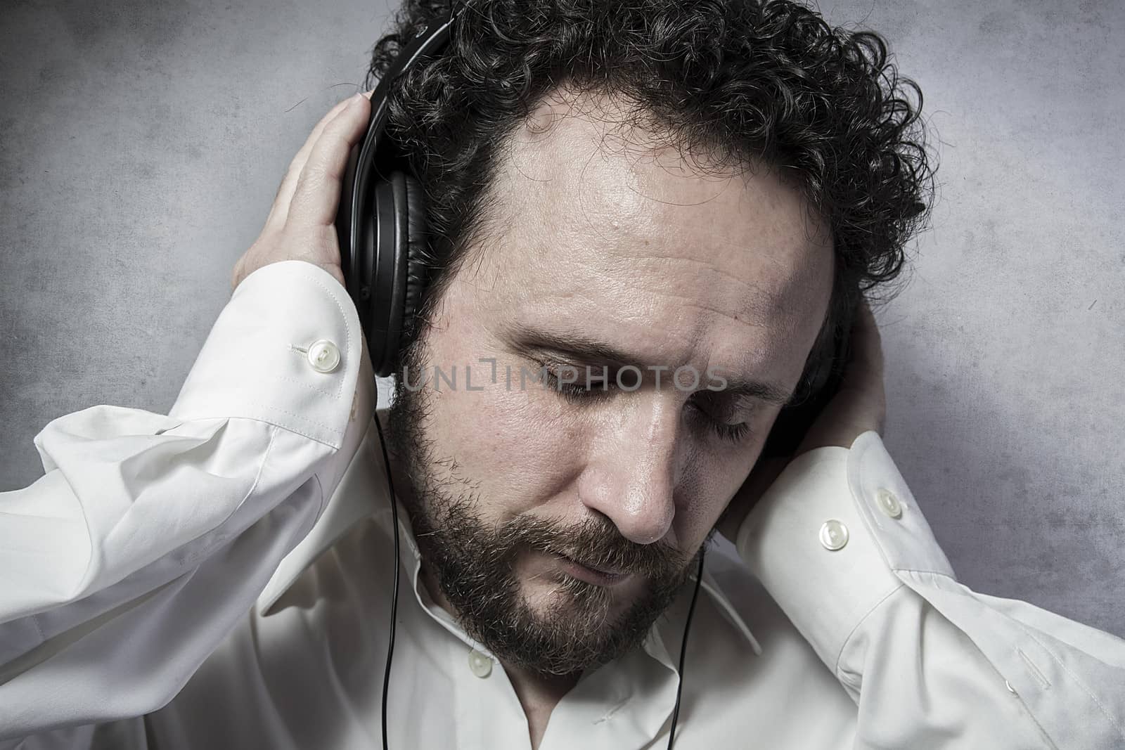 listening and enjoying music with headphones, man in white shirt with funny expressions