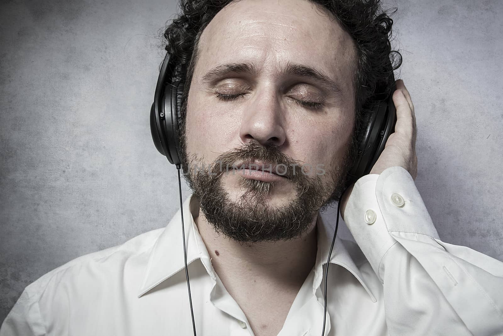 Trendy, listening and enjoying music with headphones, man in whi by FernandoCortes