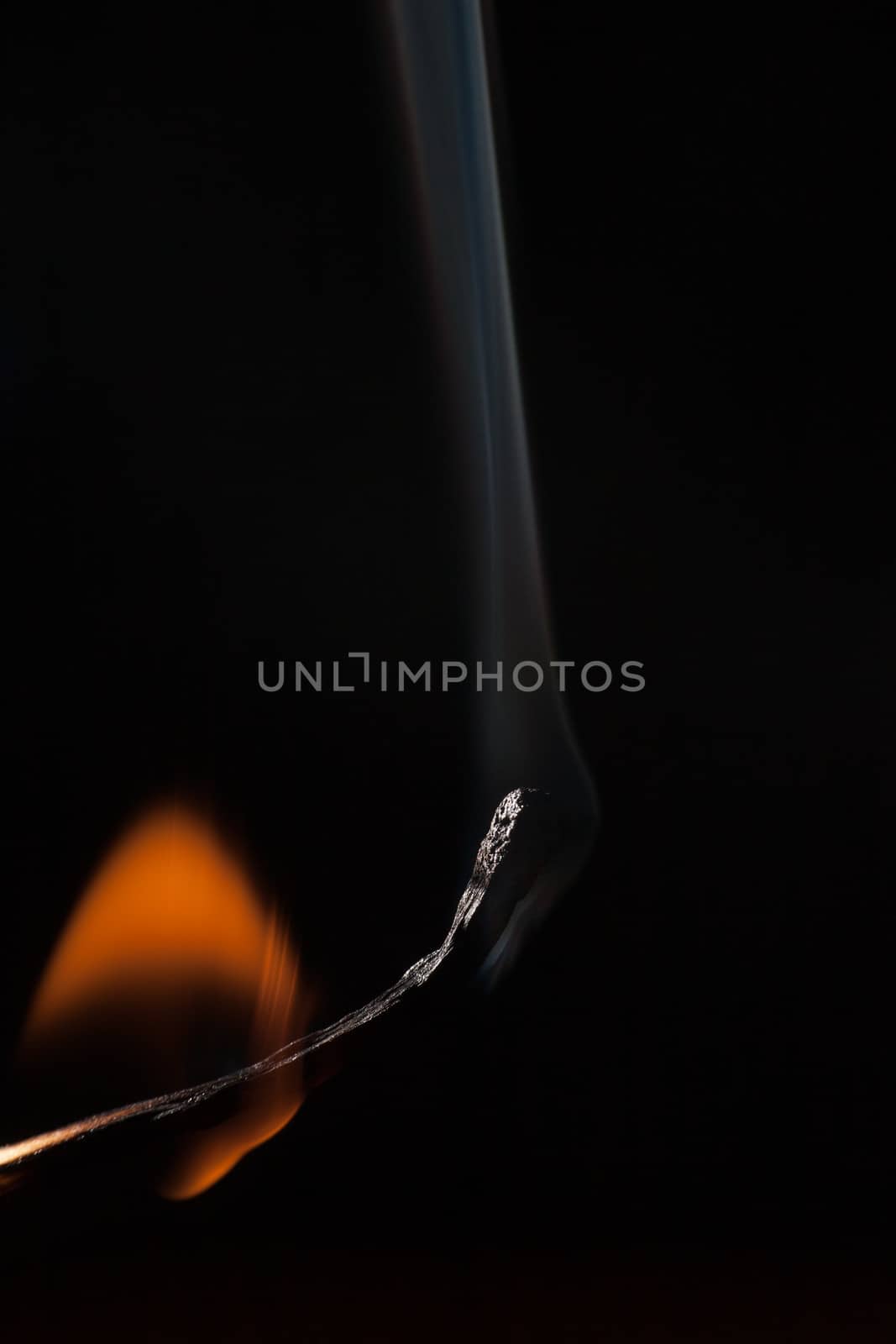 Burning match on a black background 