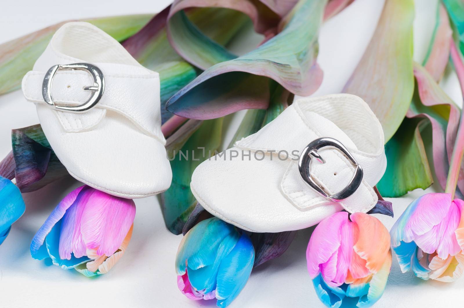 White baby shoes and unusual multi colored tulips