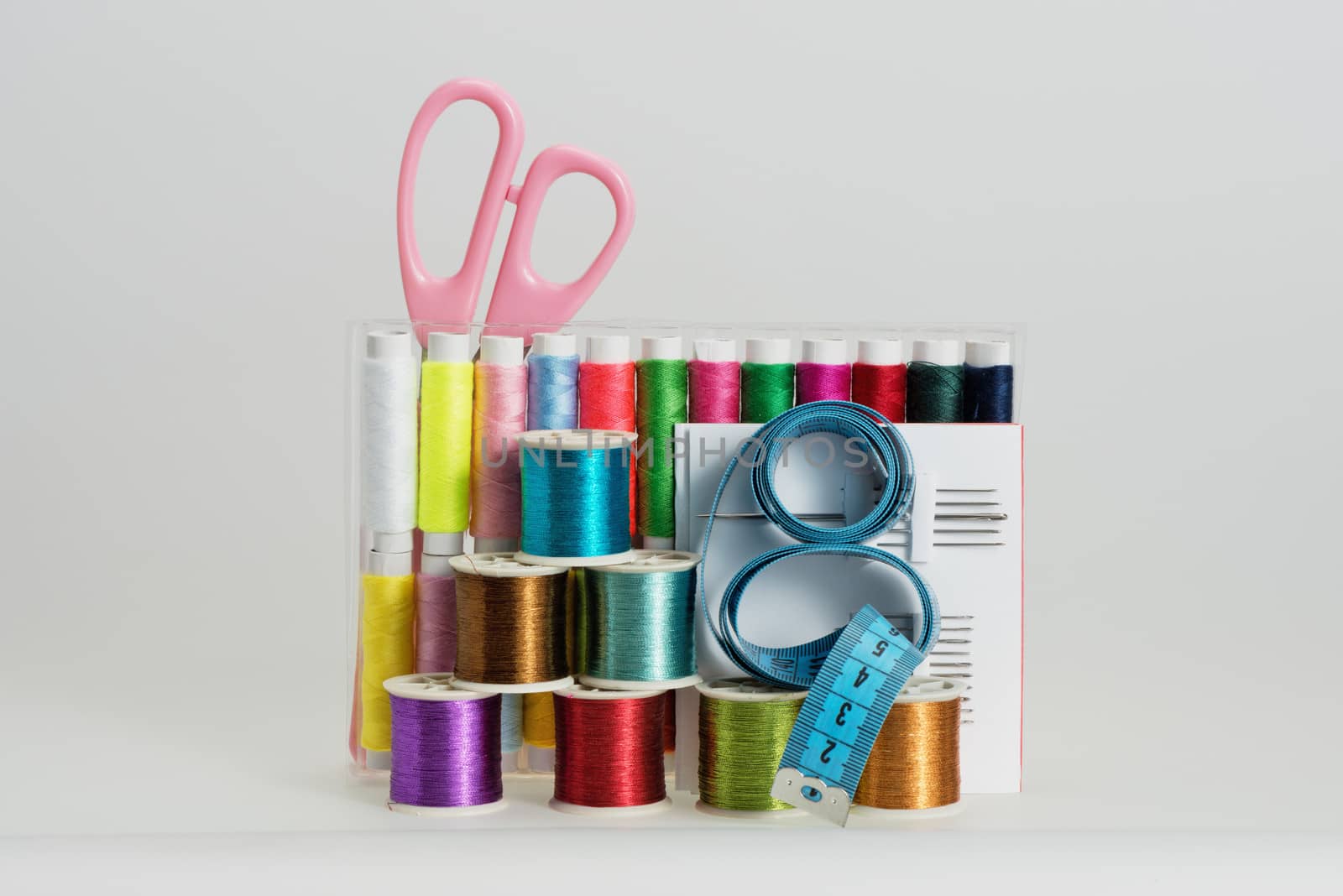 Coils with color strings of various color, sewing needles, scissors and sartorial centimeter