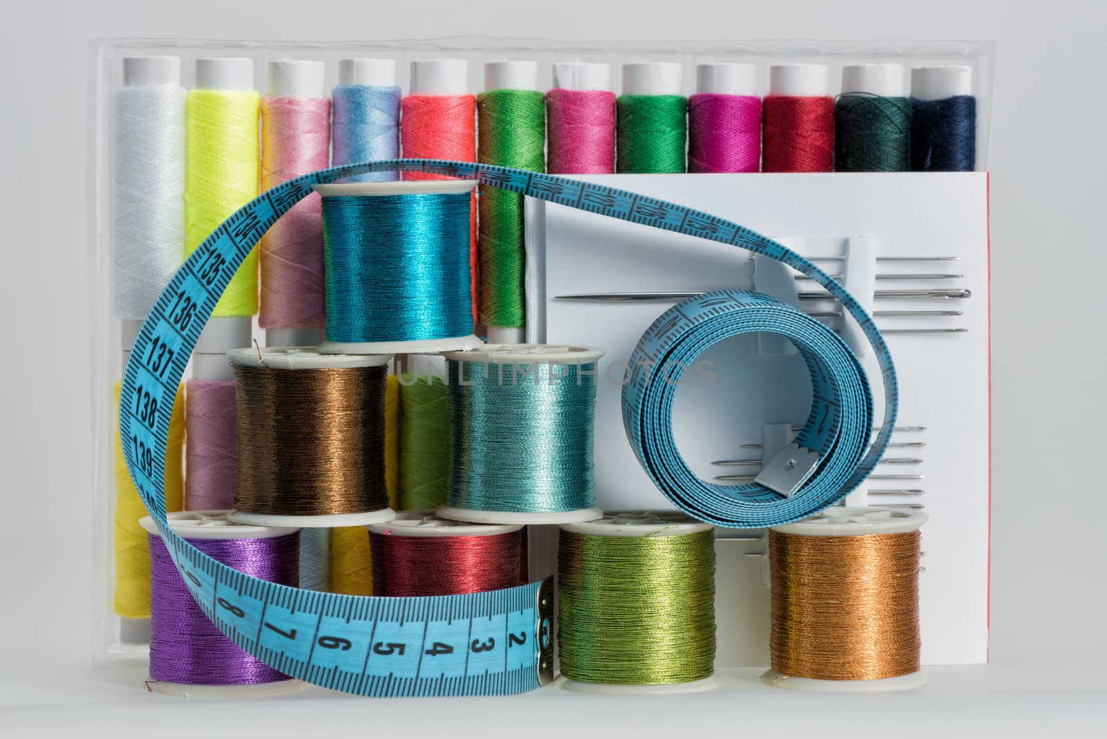 Coils with color threads, sewing needles, scissors by fotooxotnik