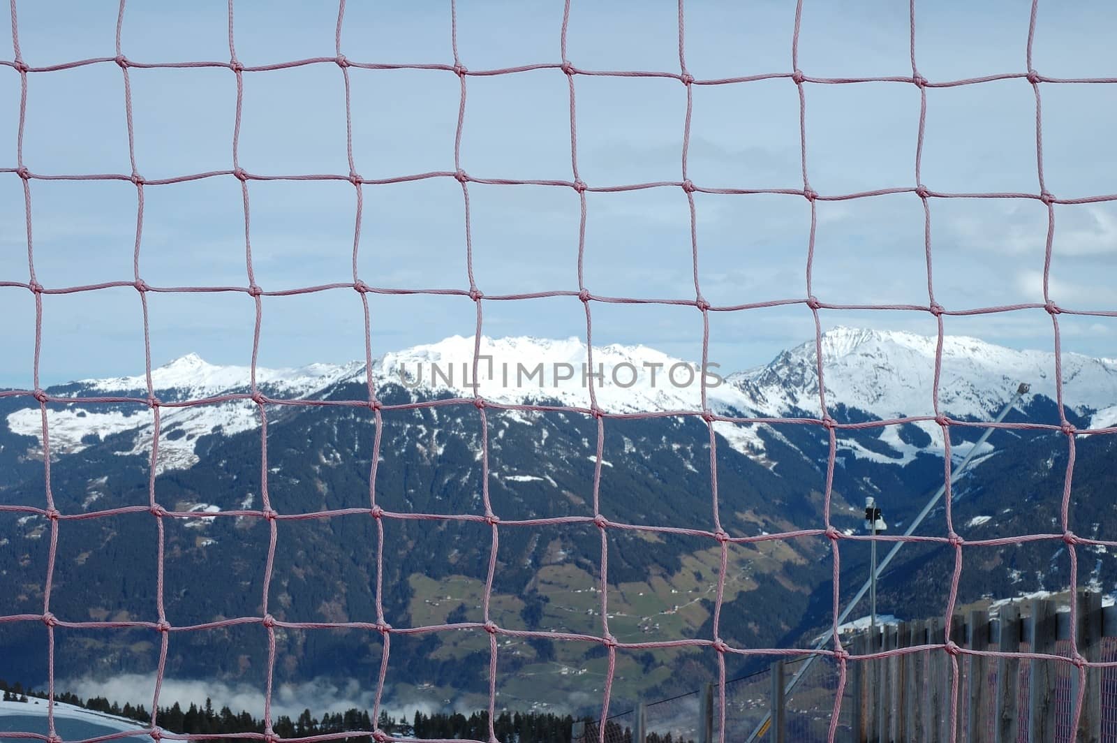 Viev through net hanging nearby slope in Alps nearby Kaltenbach in Zillertal valley in Austria