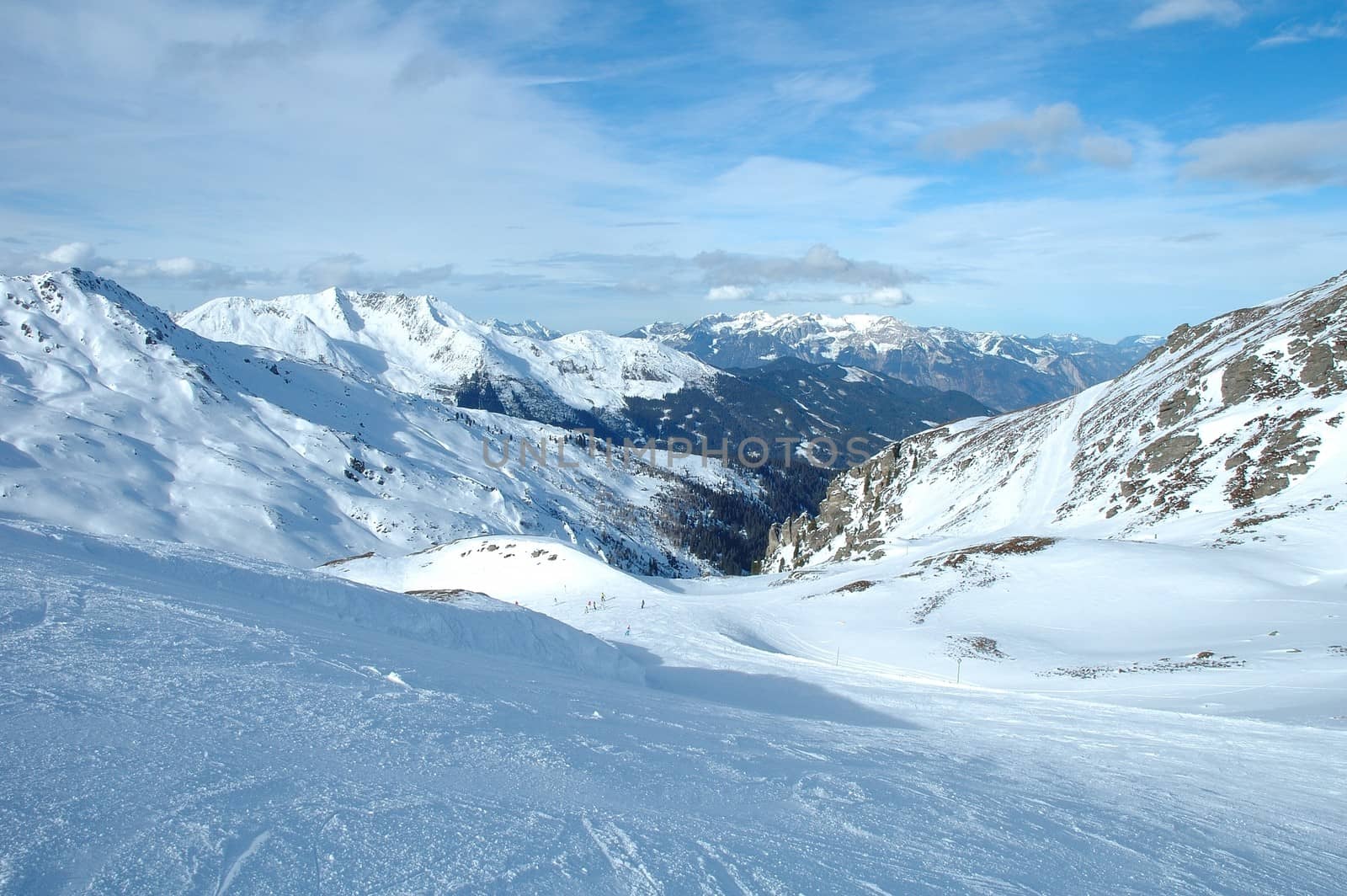 Ski slope, peaks and valley in Alps in winter by janhetman