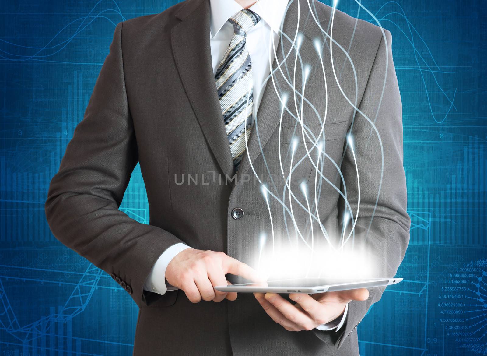 Businessman in a suit holding a tablet computer. Rays emitted from the tablet